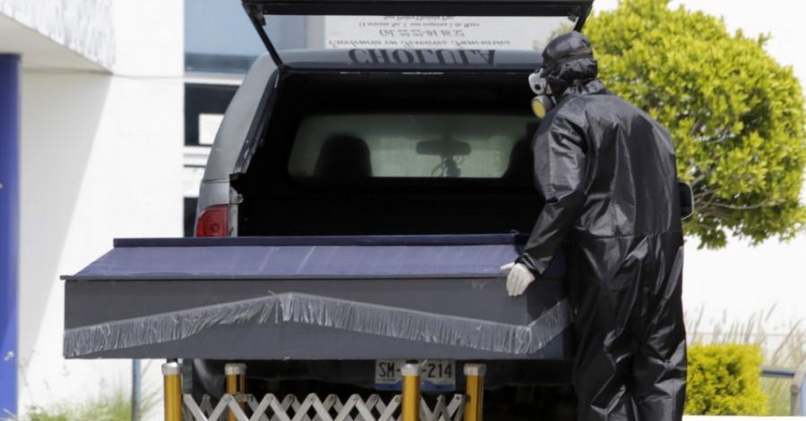 El empleado de una funeraria prepara el traslado de un cuerpo afuera del hospital General de Cholula.