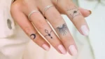 Mano de mujer con tatuajes en los dedos