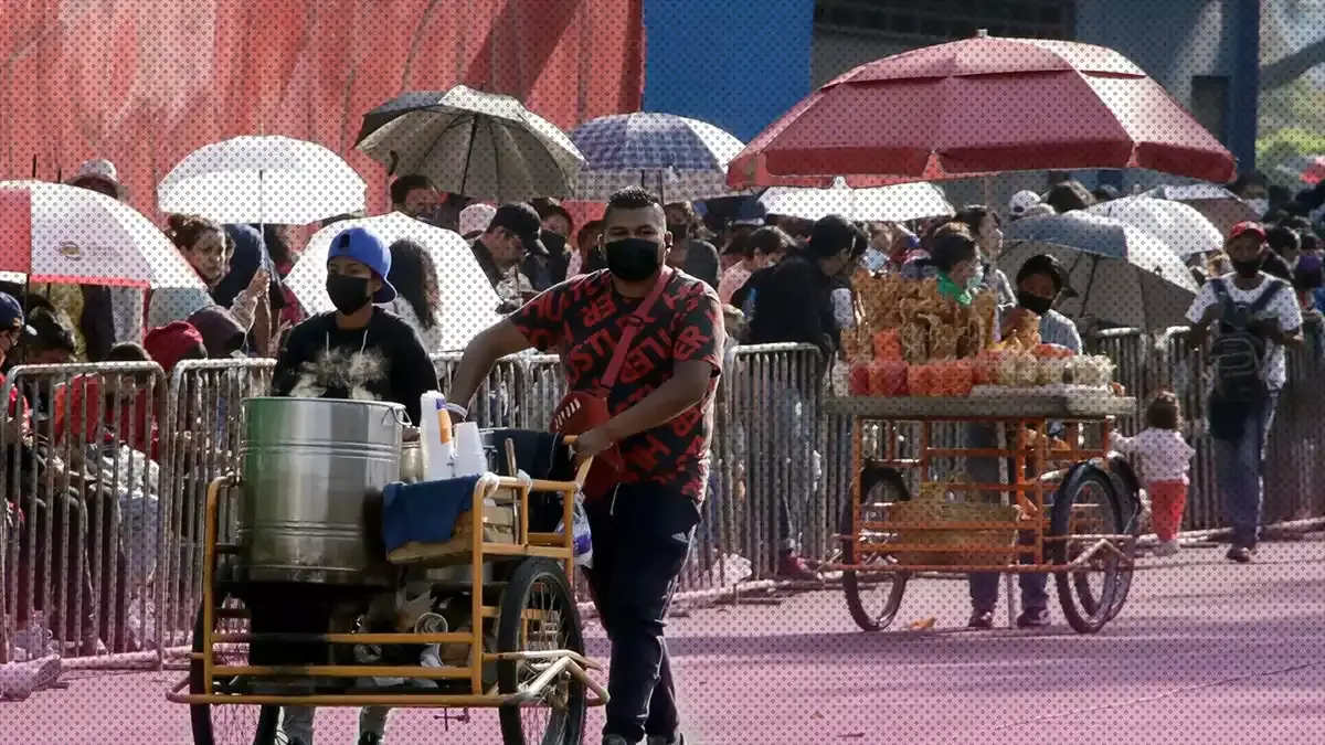 Vendedores ambulantes con carritos de tamales y botana en el desfile del 5 de Mayo